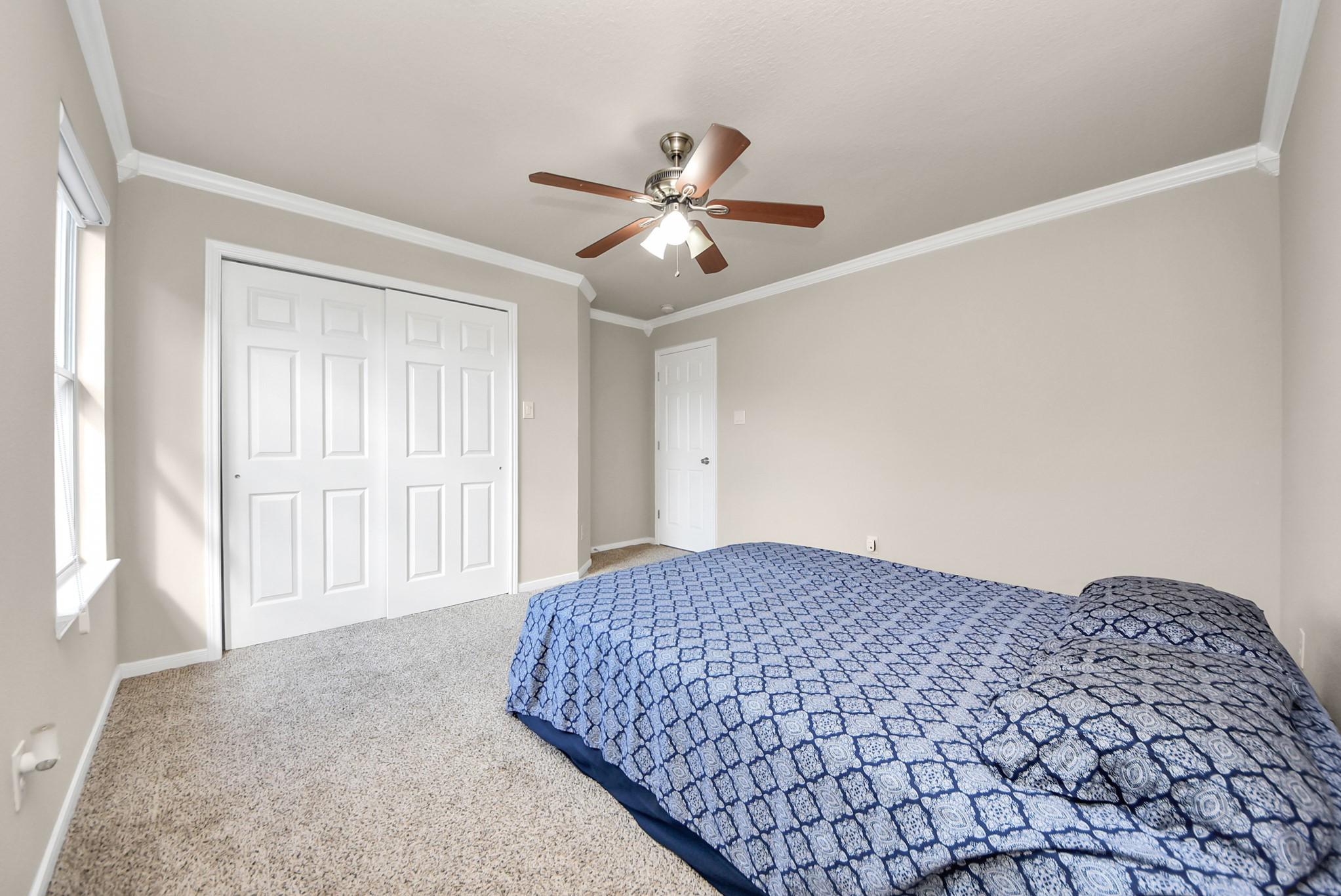 18715 Keystone Oak Street Houston, TX 77084 - Photo 37 of 50 a bedroom with a large bed and a chandelier fan