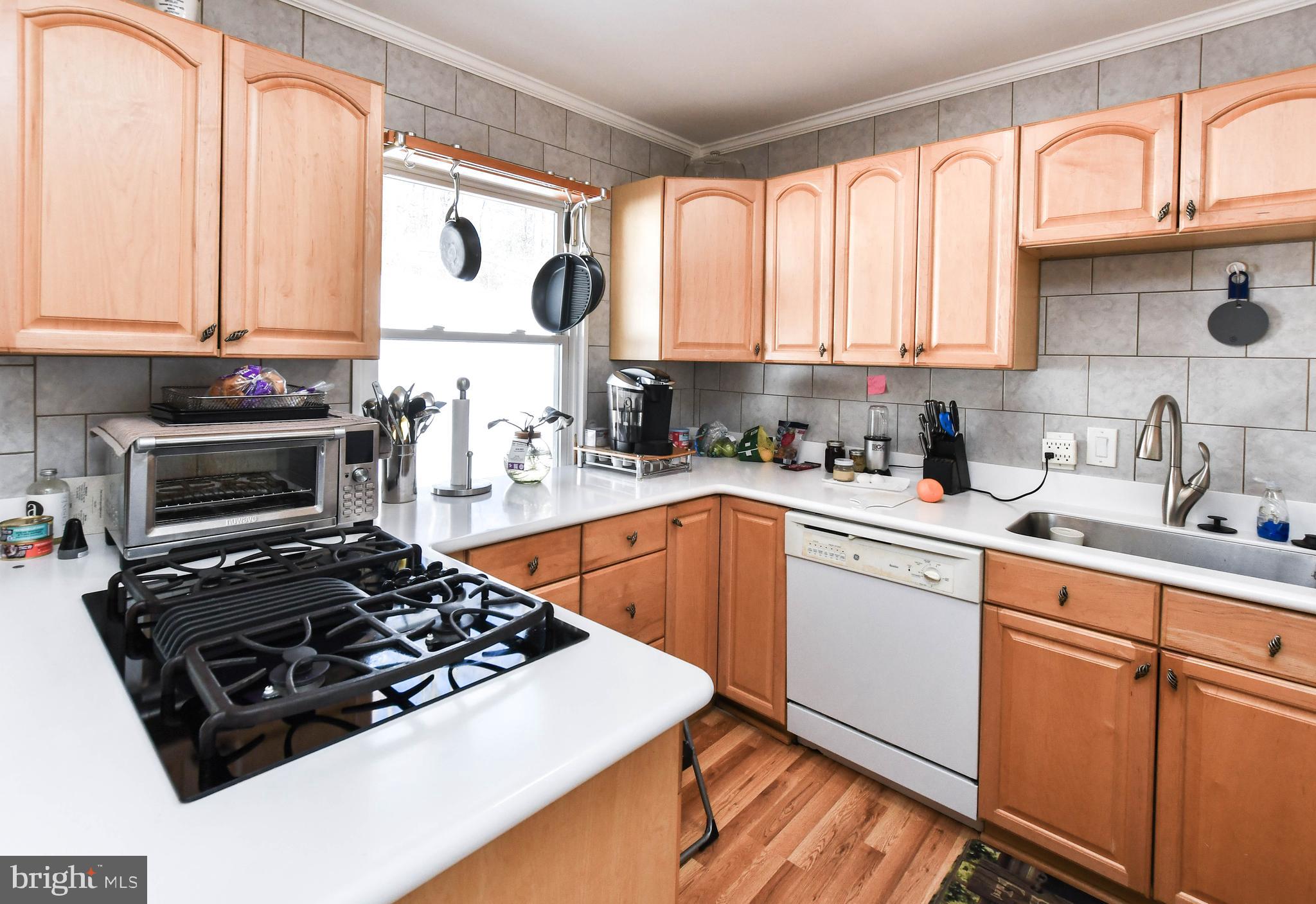6714 Darby Road Hyattsville, MD 20784 - Photo 12 of 35 a kitchen with stainless steel appliances a sink stove and white cabinets