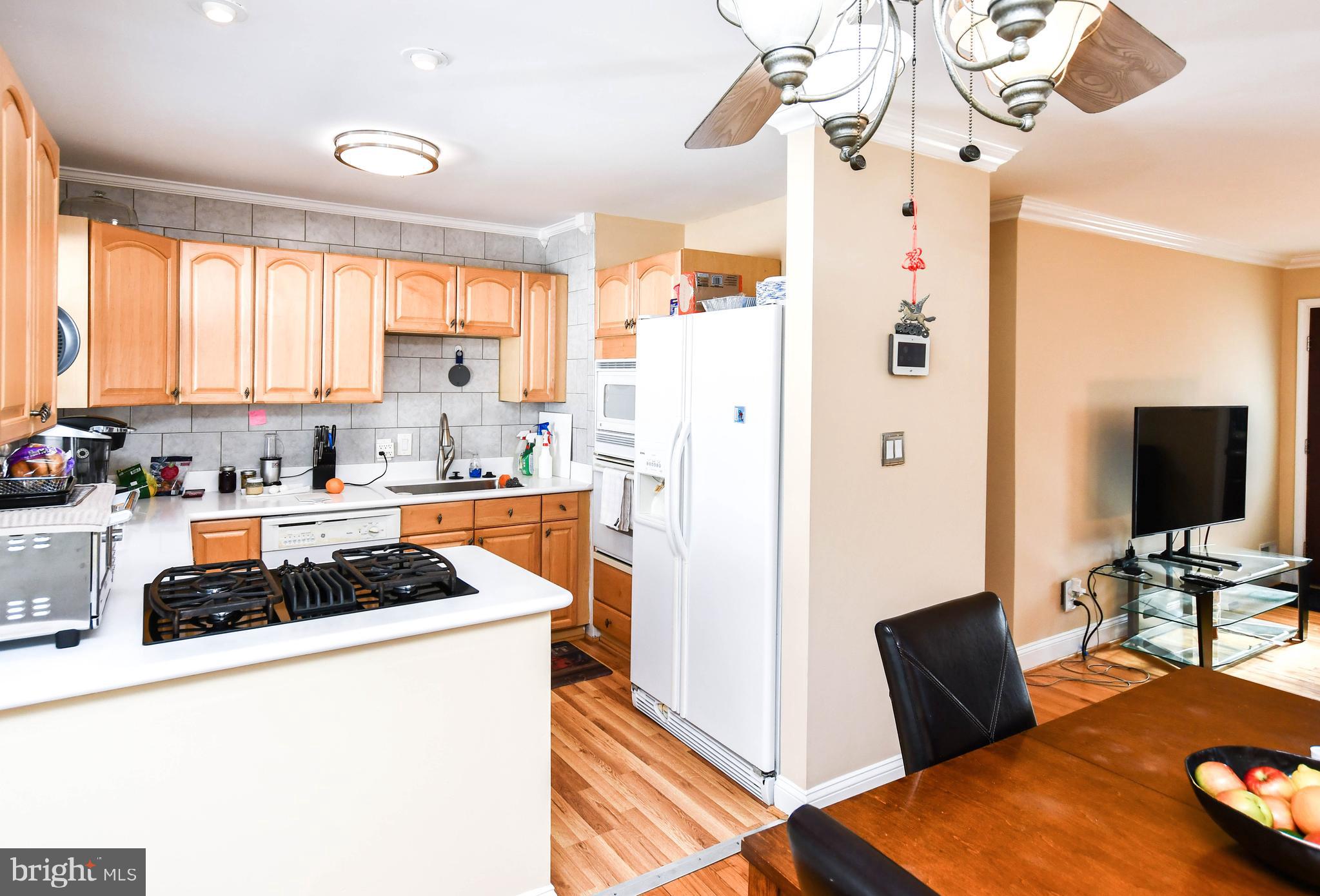 6714 Darby Road Hyattsville, MD 20784 - Photo 13 of 35 a kitchen with stainless steel appliances granite countertop a refrigerator a stove a sink dishwasher and white cabinets with wooden floor