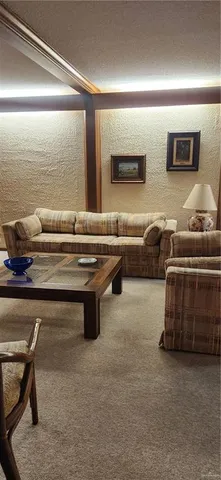 a living room with furniture and a air conditioner vent