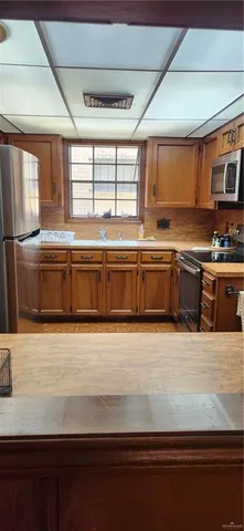 a large kitchen with granite countertop a sink and dishwasher a stove top oven with wooden floor