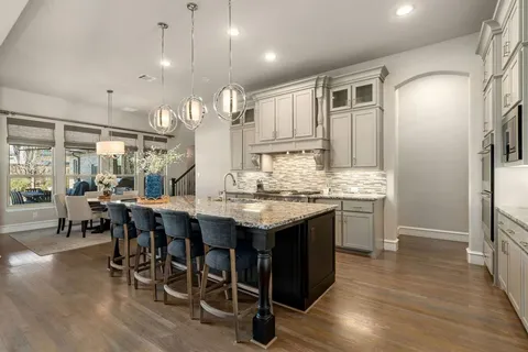 a kitchen with granite countertop a sink cabinets and wooden floor