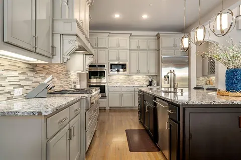 a kitchen with stainless steel appliances granite countertop a stove a sink and a microwave