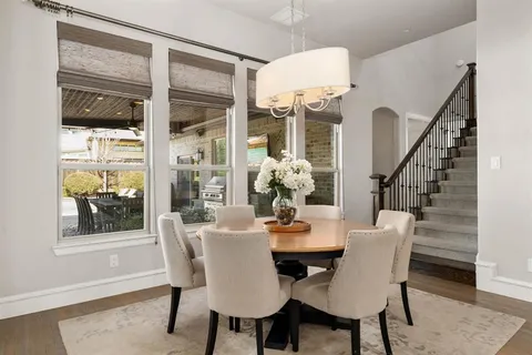 a dining room with furniture a rug and a potted plant