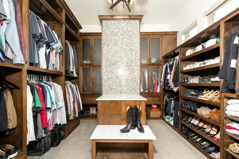 a view of walk in closet with clothes and shoes