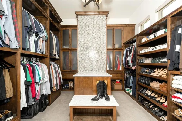 a view of walk in closet with clothes and shoes