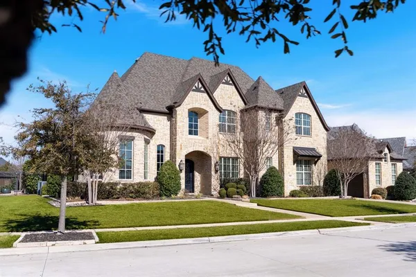 a front view of a house with a yard and trees