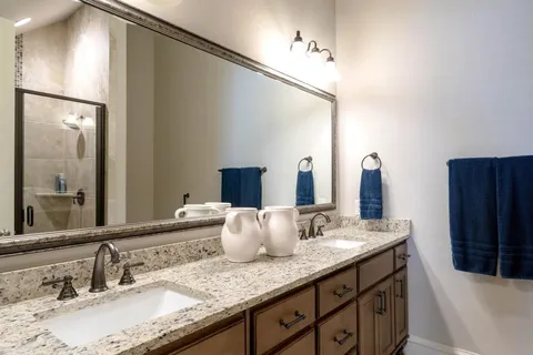a bathroom with a granite countertop sink and a mirror