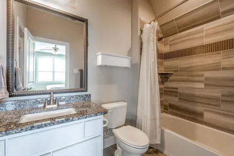 a bathroom with a granite countertop sink toilet and shower