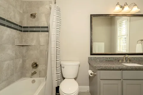 a bathroom with a granite countertop sink toilet and shower