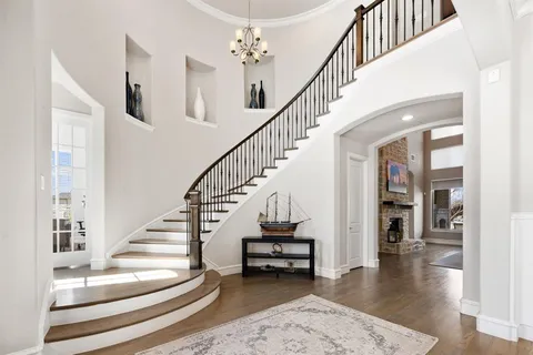 a view of staircase with lots of frames and frames on wall next to a window