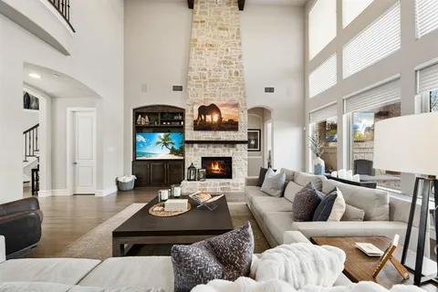 a living room with furniture fireplace and a large window