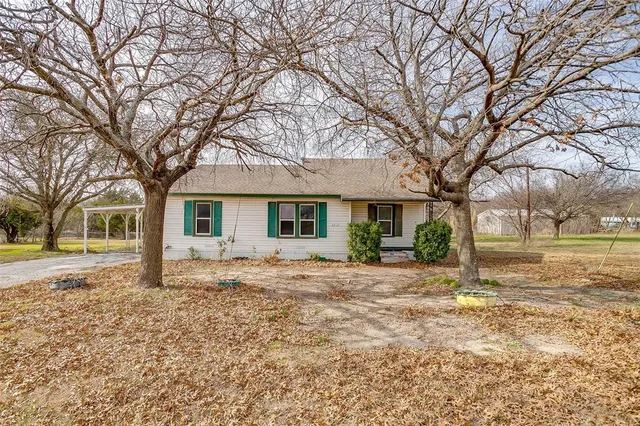 a front view of a house with a yard and trees