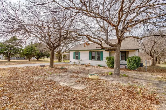 a front view of house with yard and trees