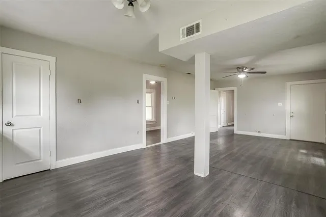 a view of an empty room with wooden floor