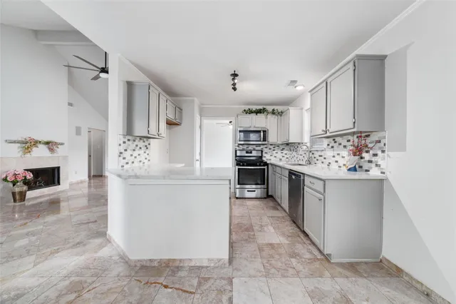 a large kitchen with kitchen island a sink stainless steel appliances and cabinets