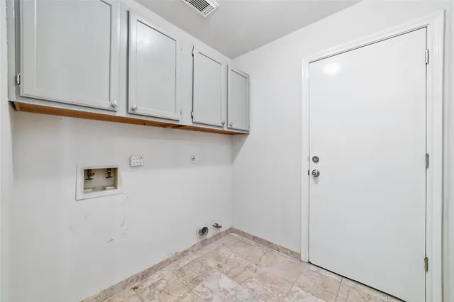 an empty room with chandelier fan and windows