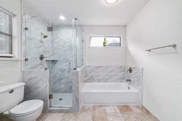 a spacious bathroom with a granite countertop sink mirror vanity and toilet