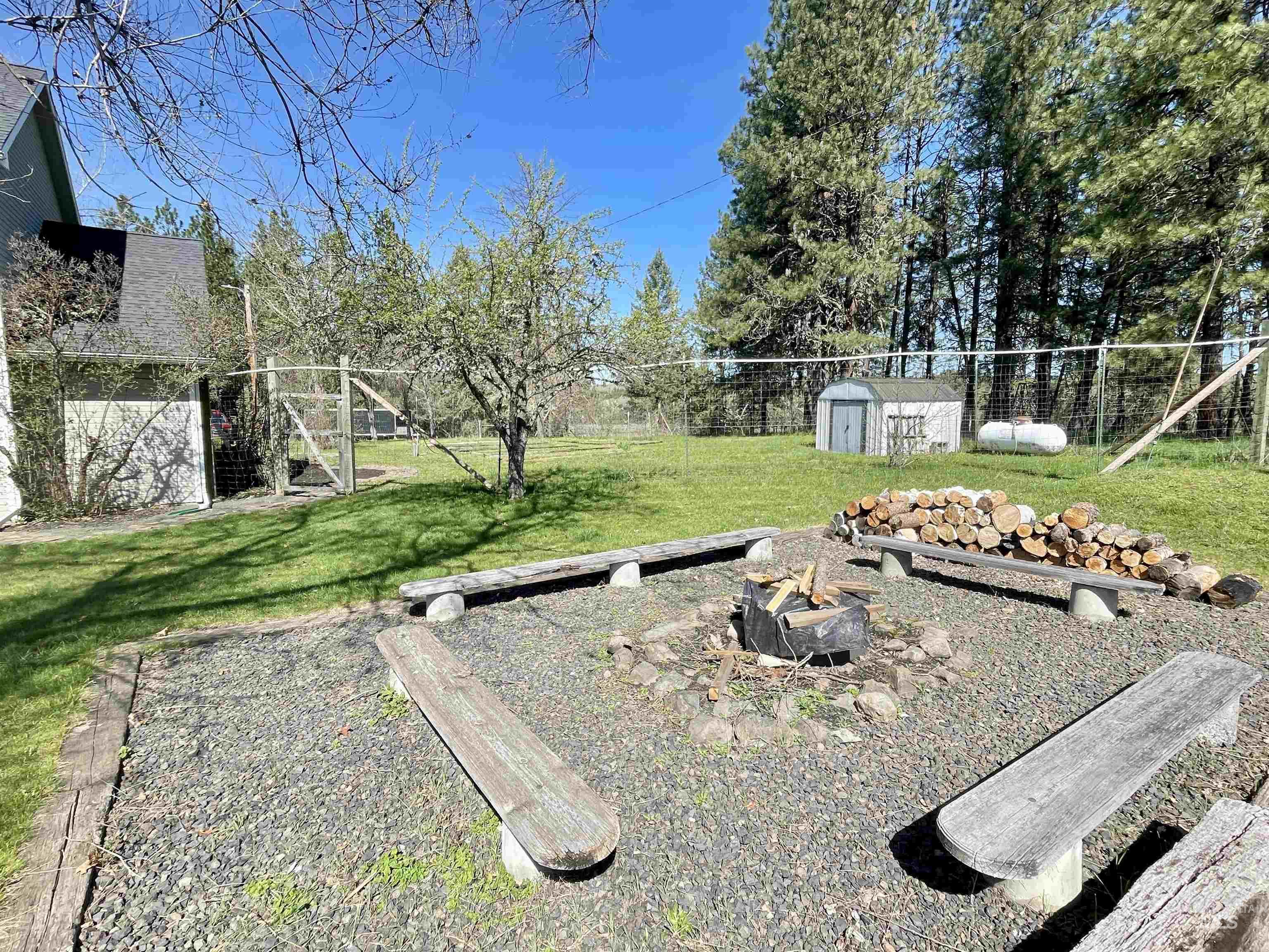 637 Leitch Creek Road Kooskia, ID 83539 - Photo 24 of 38 Fenced backyard featuring an outdoor fire pit and a storage shed