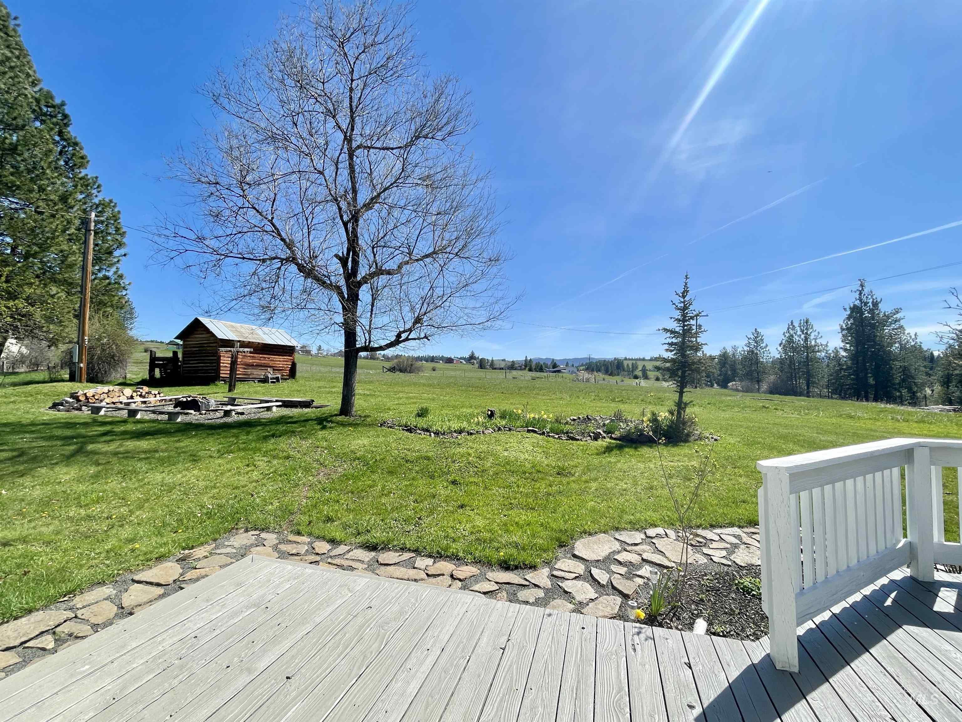 637 Leitch Creek Road Kooskia, ID 83539 - Photo 27 of 38 Wooden deck featuring an outbuilding, a lawn, and a rural view