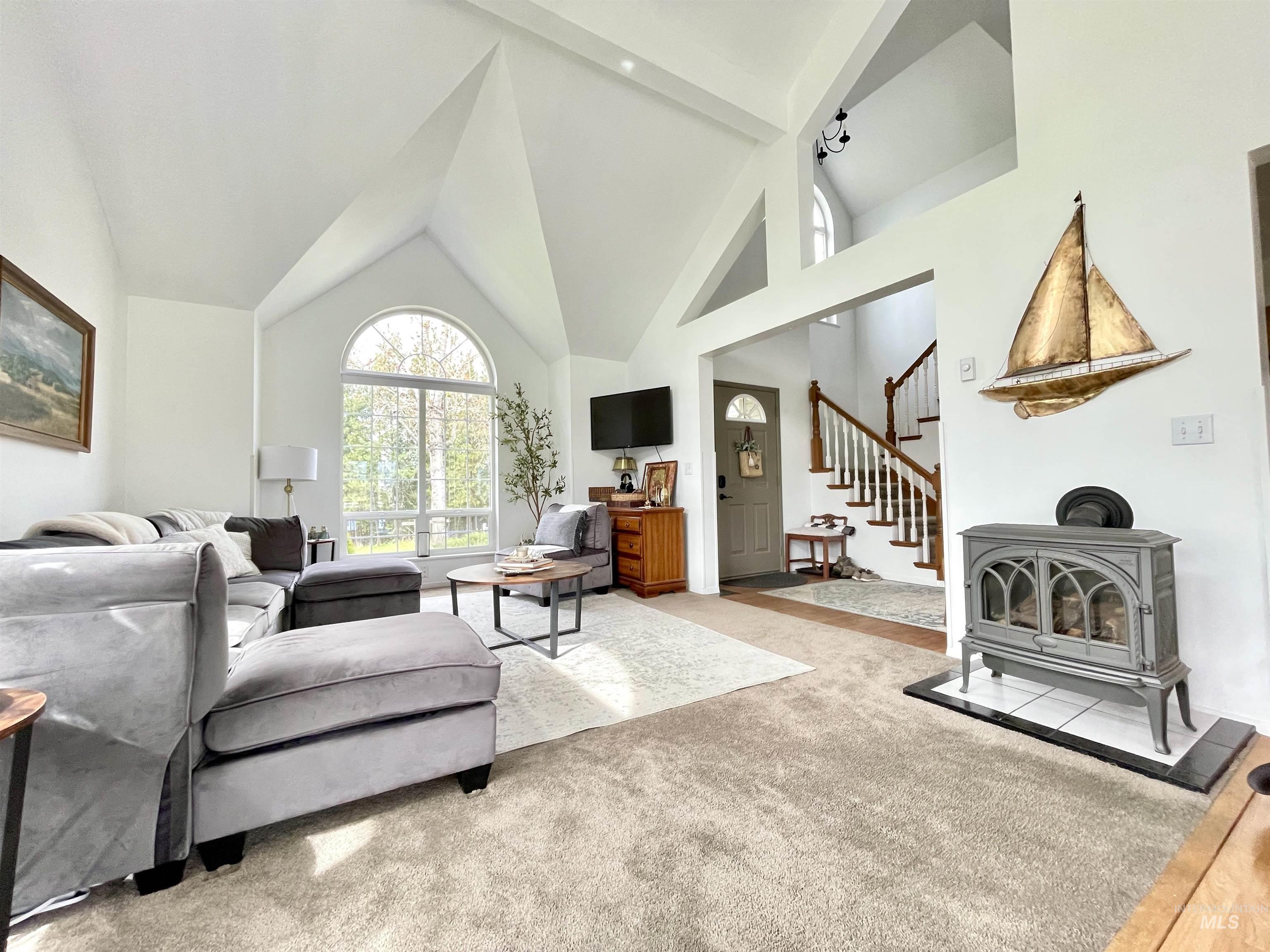 637 Leitch Creek Road Kooskia, ID 83539 - Photo 7 of 38 Carpeted living area with lofted ceiling and a wood stove