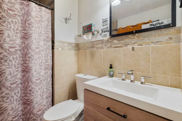 a bathroom with a sink a toilet and shower curtain