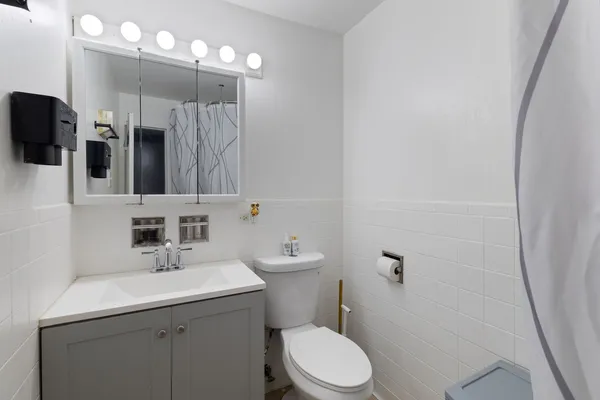 a bathroom with a sink a toilet and mirror