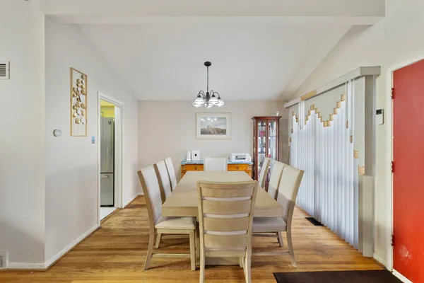 a dining room with furniture a chandelier and wooden floor