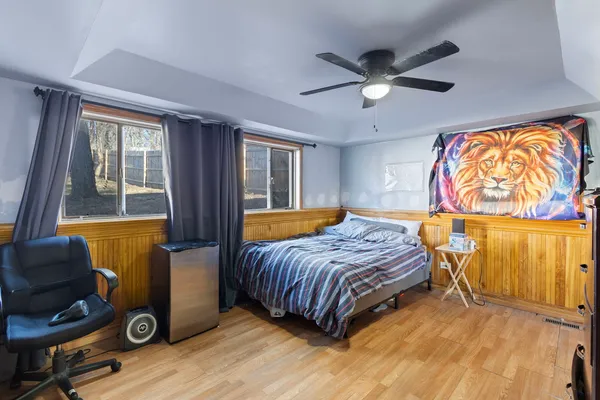 a bedroom with a bed and wooden floor
