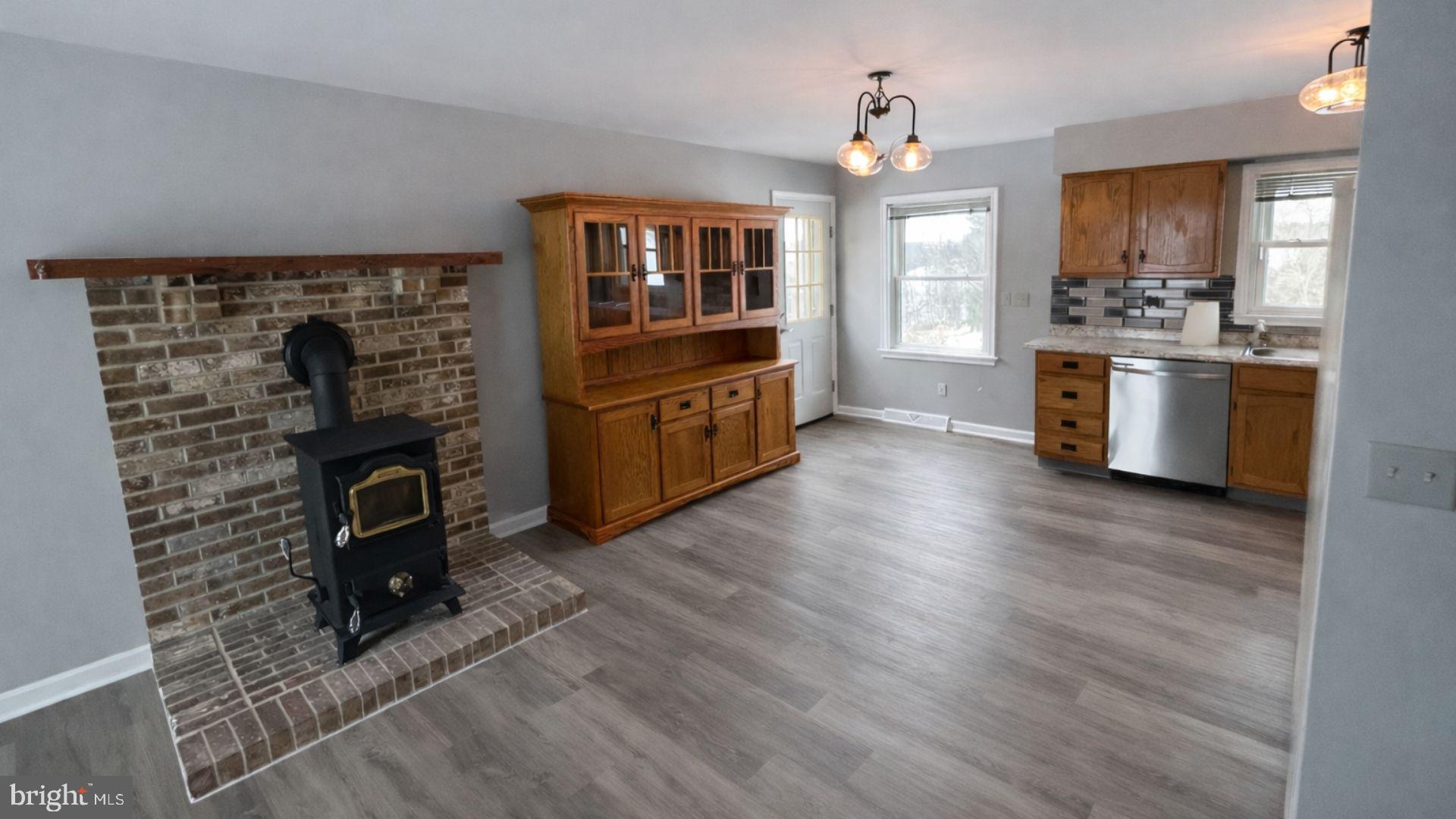 2134 Cemetery Road Seven Valleys, PA 17360 - Photo 3 of 10 a kitchen with granite countertop a stove top oven a sink dishwasher and a fireplace