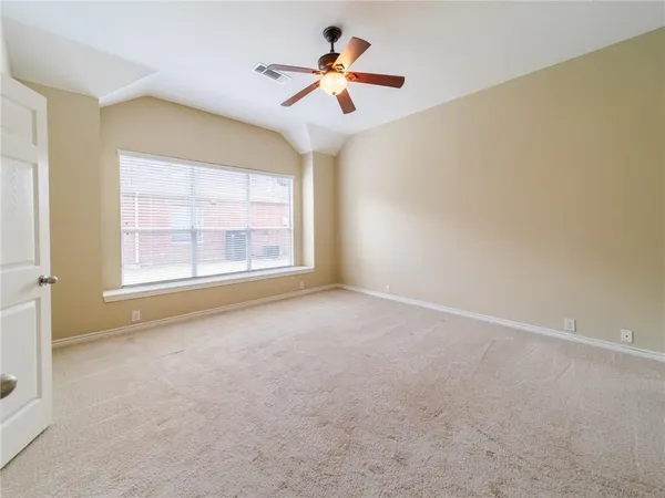 a view of a room with a ceiling fan and a window