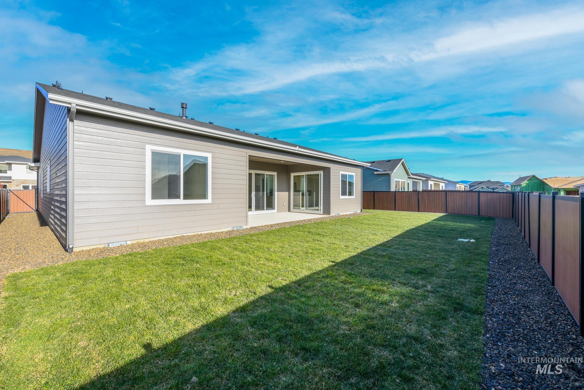 5402 Juliet Rose Avenue Caldwell, ID 83607 - Photo 11 of 20 Expansive backyard featuring a manicured lawn, a brown panel privacy fence, and a gravel border