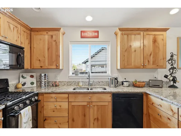 a kitchen with granite countertop a sink cabinets and stainless steel appliances