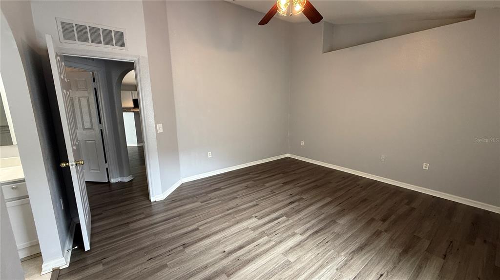 2210 Nicollett Way Leesburg, FL 34748 - Photo 15 of 31 an empty room with wooden floor and chandelier fan
