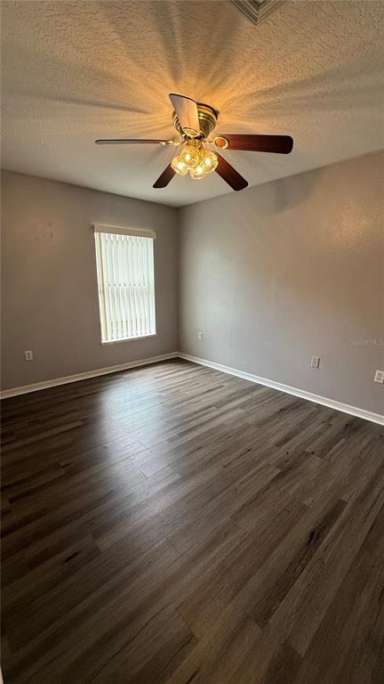 2210 Nicollett Way Leesburg, FL 34748 - Photo 21 of 31 a view of an empty room with wooden floor and a window