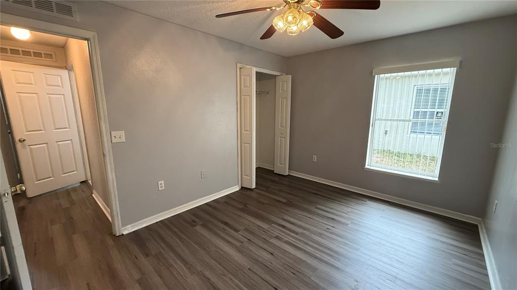 2210 Nicollett Way Leesburg, FL 34748 - Photo 22 of 31 an empty room with wooden floor and windows
