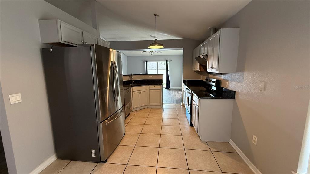 2210 Nicollett Way Leesburg, FL 34748 - Photo 5 of 31 a kitchen with stainless steel appliances granite countertop a refrigerator a sink a stove and dishwasher