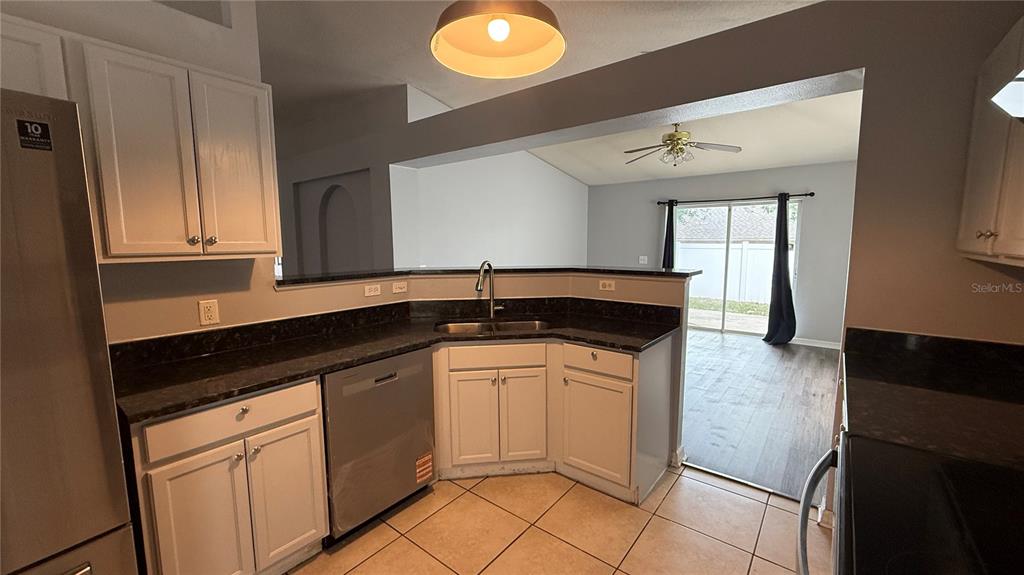 2210 Nicollett Way Leesburg, FL 34748 - Photo 6 of 31 a kitchen with granite countertop white cabinets and white appliances