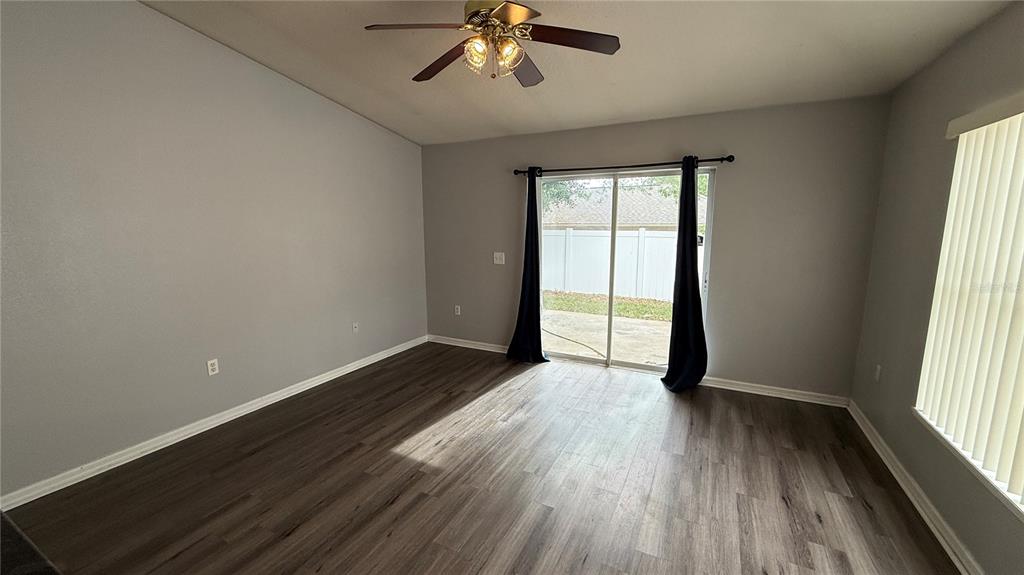 2210 Nicollett Way Leesburg, FL 34748 - Photo 7 of 31 an empty room with wooden floor chandelier and windows