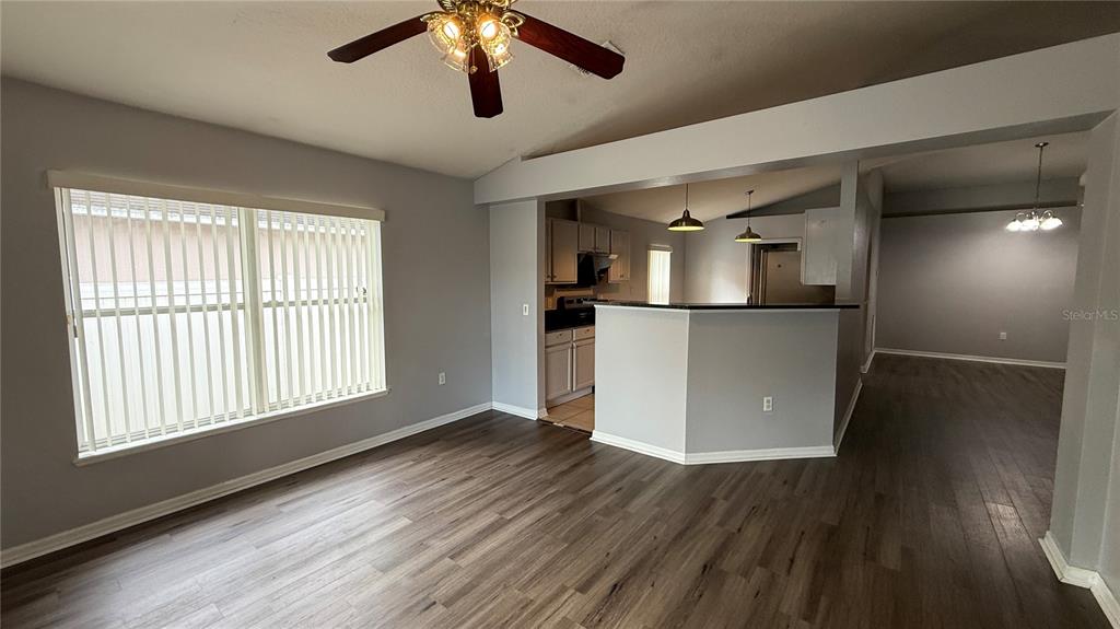2210 Nicollett Way Leesburg, FL 34748 - Photo 9 of 31 a view of a livingroom with wooden floor and a kitchen