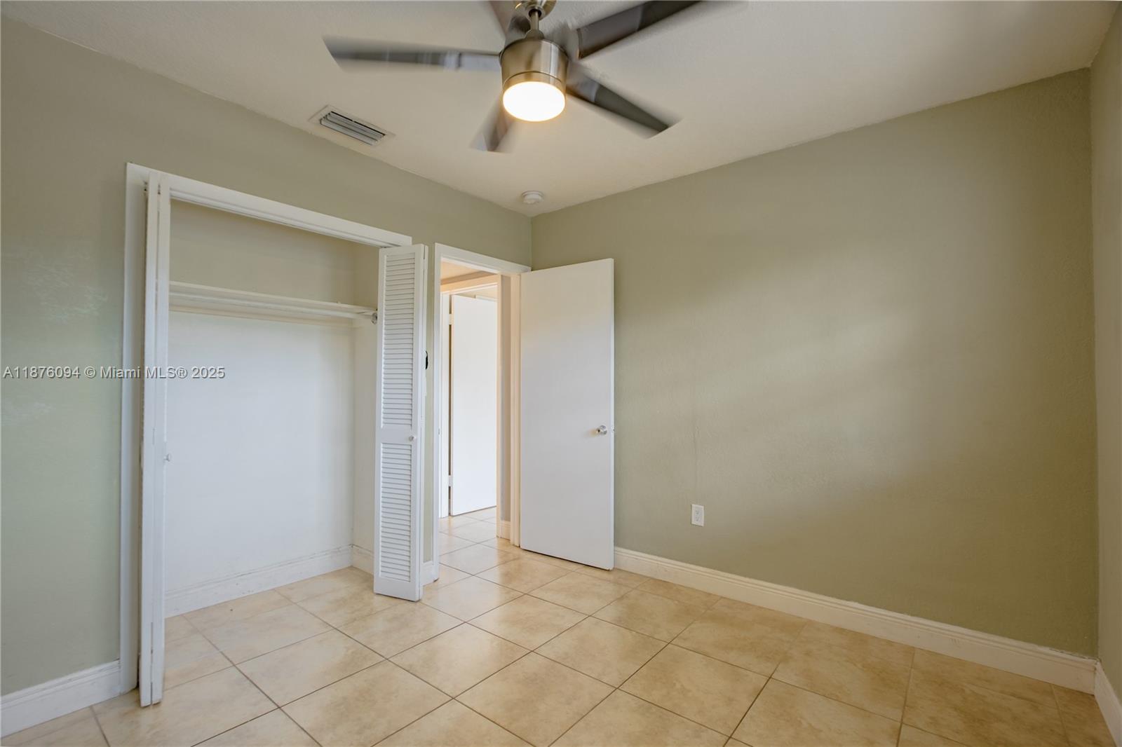 120 Royal Palm Road, Unit 315 Hialeah Gardens, FL 33016 - Photo 8 of 15 an empty room with closet and a chandelier fan