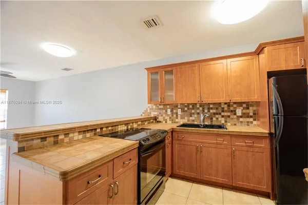 a kitchen with a sink a stove cabinets and a refrigerator