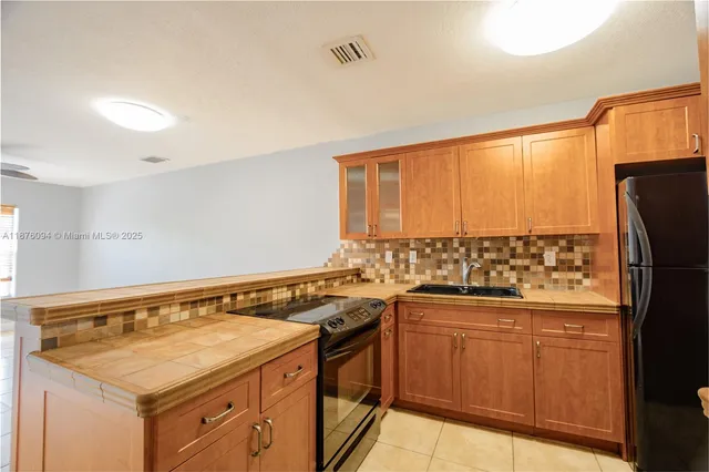 a kitchen with a sink a stove cabinets and a refrigerator