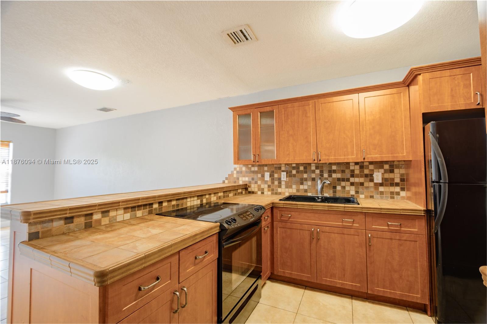120 Royal Palm Road, Unit 315 Hialeah Gardens, FL 33016 - Photo 10 of 15 a kitchen with a sink a stove cabinets and a refrigerator