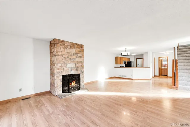 a view of empty room with fireplace and wooden floor