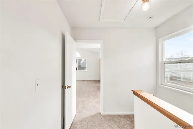 a view of hallway with a large window and chandelier
