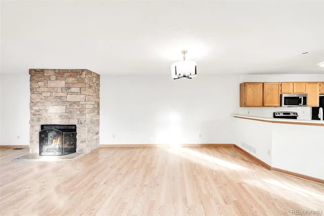 a view of empty room with wooden floor and fireplace