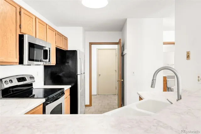 a kitchen with stainless steel appliances kitchen island a stove a refrigerator and a sink