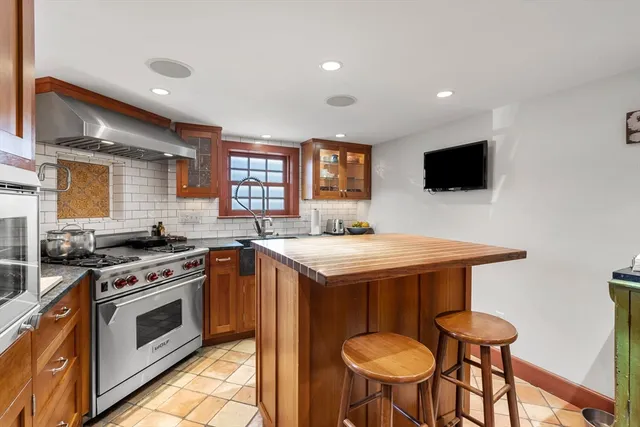 a kitchen with granite countertop a sink stove and cabinets