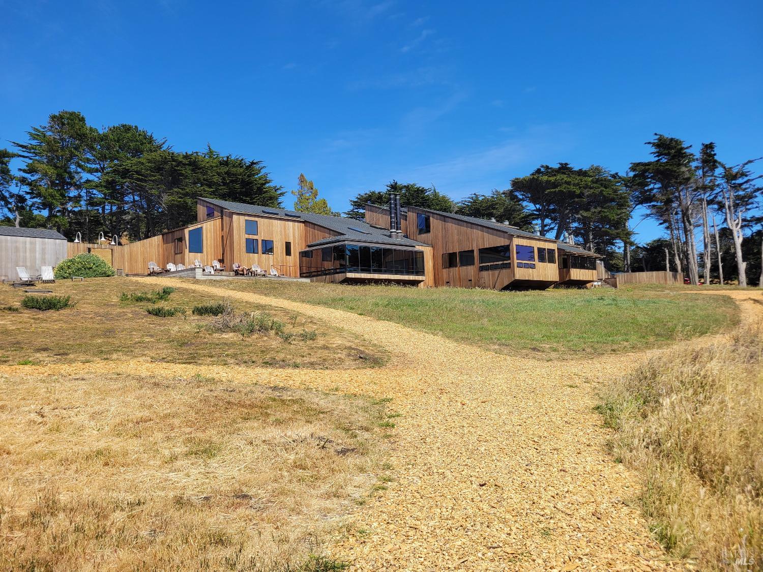 315 Chinquapin Lane The Sea Ranch, CA 95497 - Photo 9 of 18 a view of a large white house with a swimming pool and lawn chairs